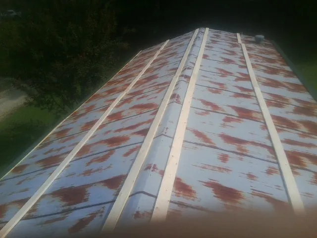 Rusted metal roof panels with new wood purlins before replacement — Storm Damage Roof Repair in Flanagan by Roofing Brothers