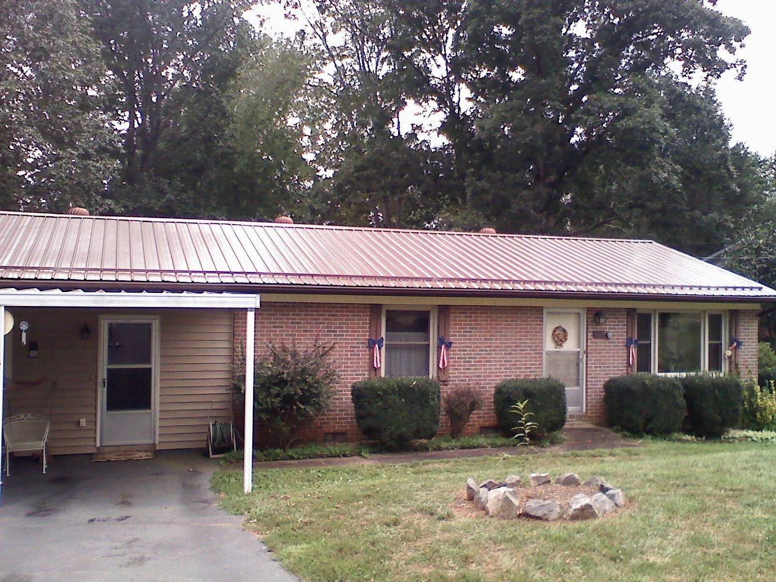 Bronze metal roof and carport on a brick ranch home — Roof Repair work by our crew in Flanagan